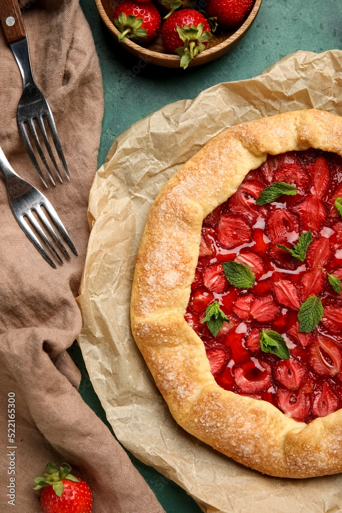 Tasty strawberry galette on green background, closeup