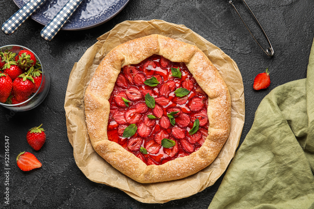 Composition with sweet strawberry galette and fresh berries on dark background