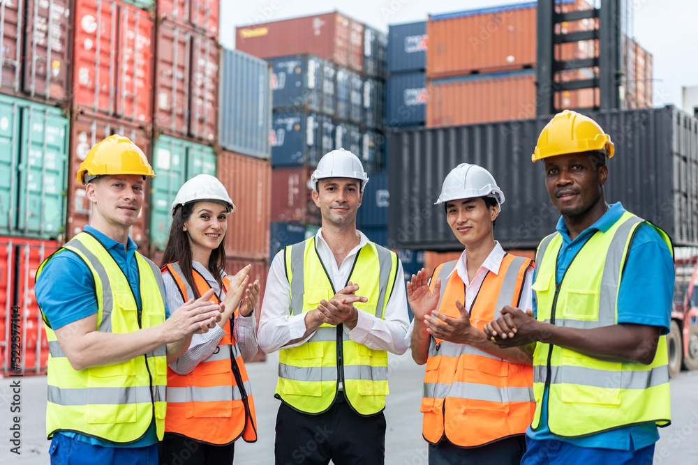 Group of man and woman worker clap hands while work in container port. 