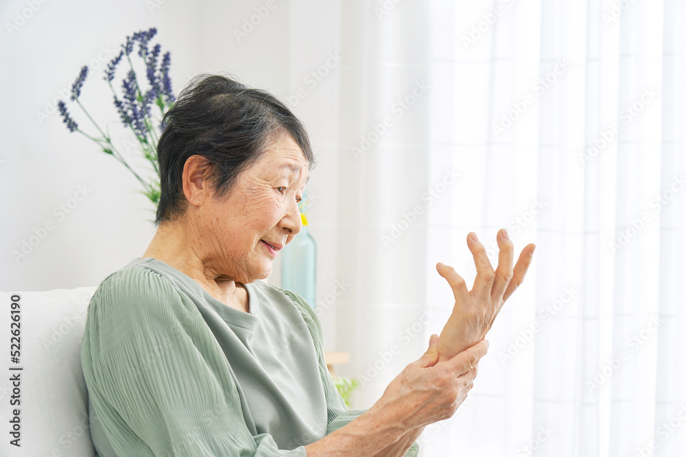 自宅で手が痺れるシニア女性