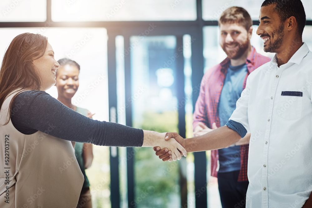 Business people giving handshake, welcoming new employee and standing united while colleagues clap i