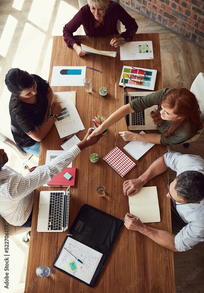 Handshake, agreement and greeting team of creative designers during a meeting working together. Over