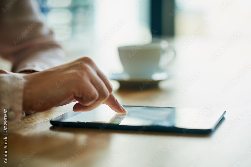 Closeup of business hands working on a digital tablet in a modern office. Professional at work on to