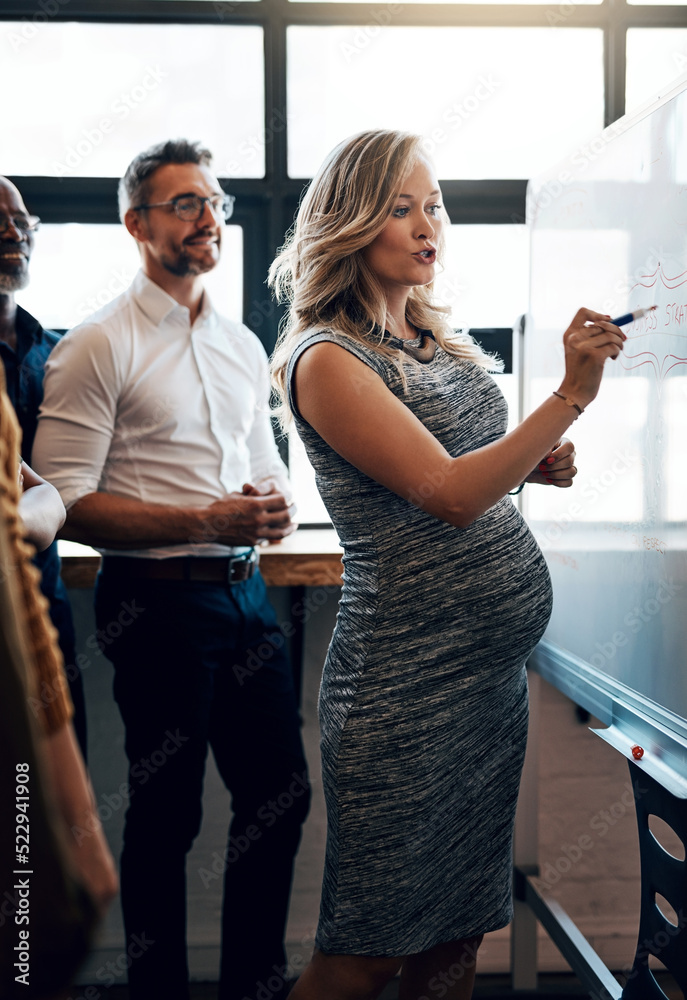 Pregnant businesswoman doing a presentation in a meeting planning the company growth strategy in an 