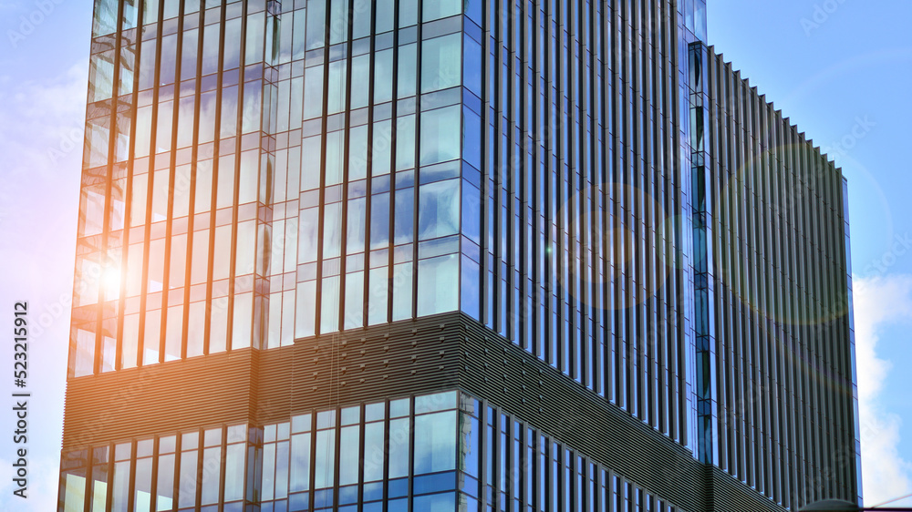  Modern glass facade against blue sky. Bottom view of a  building in the business district. Low angl