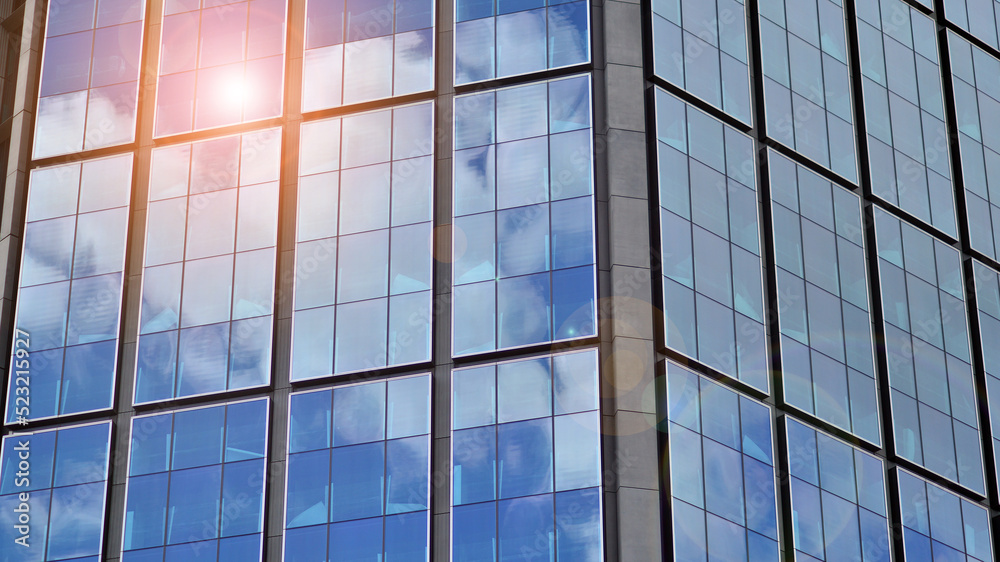  Modern glass facade against blue sky. Bottom view of a  building in the business district. Low angl