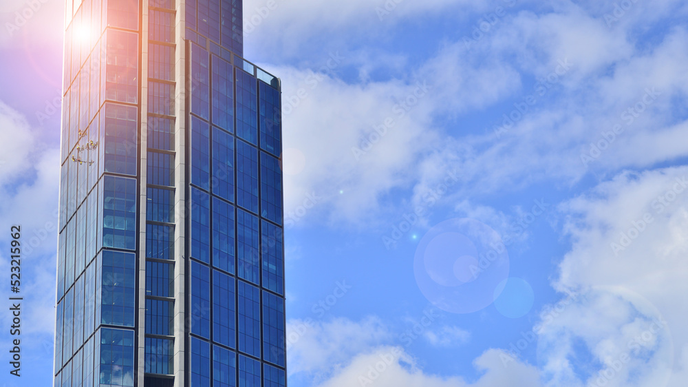 Modern glass facade against blue sky. Bottom view of a  building in the business district. Low angle