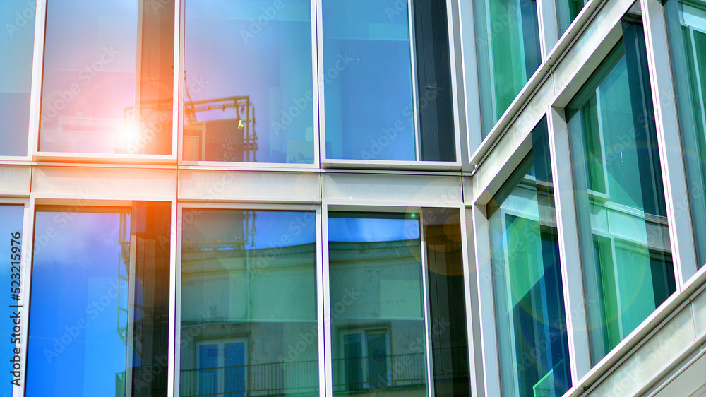 Modern glass facade against blue sky. Bottom view of a  building in the business district. Low angle