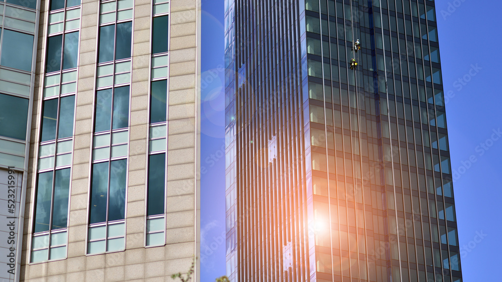 Modern glass facade against blue sky. Bottom view of a  building in the business district. Low angle