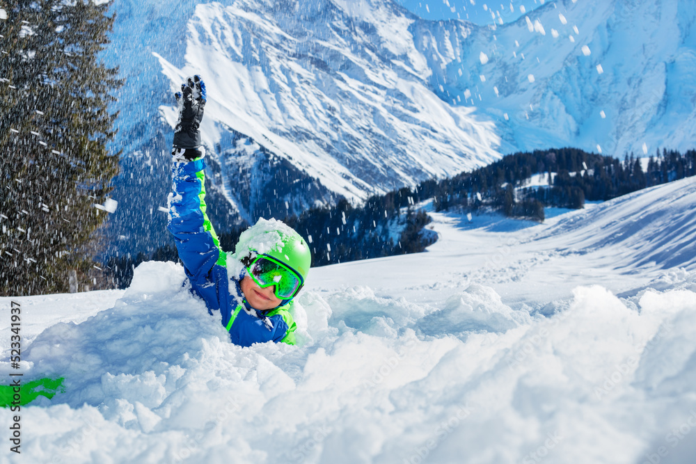 Fun with snow - happy boy play laying in snowdrift