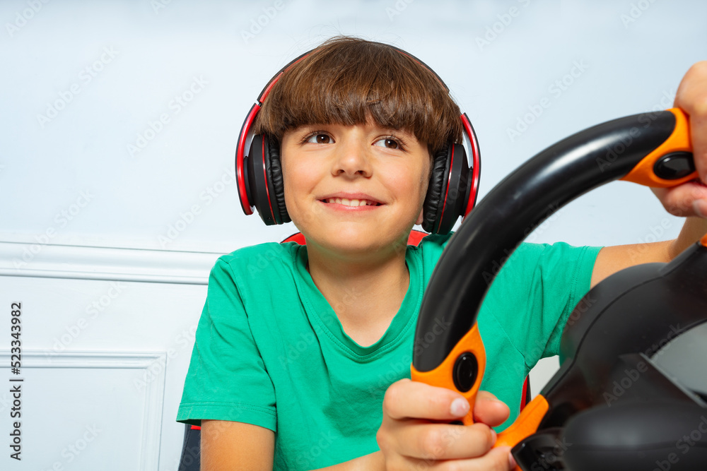 Close image with steering wheel of gamer young boy playing game