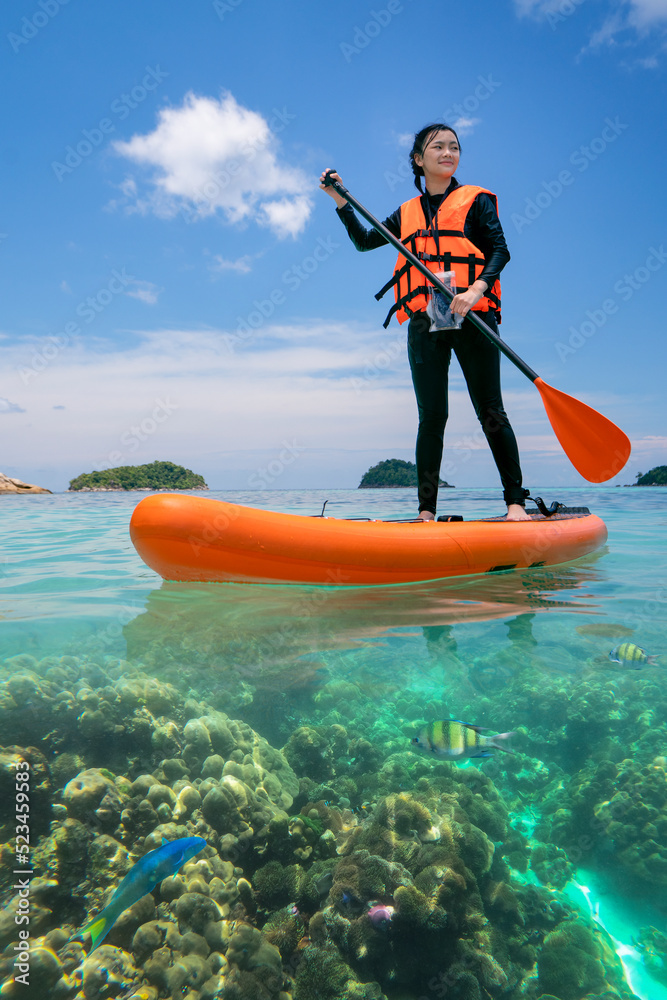 Asian woman relax on the beach with SUP BOARD