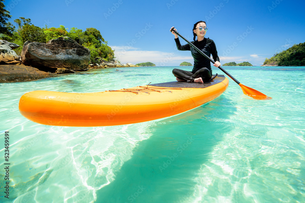 Asian woman relax on the beach with SUP BOARD