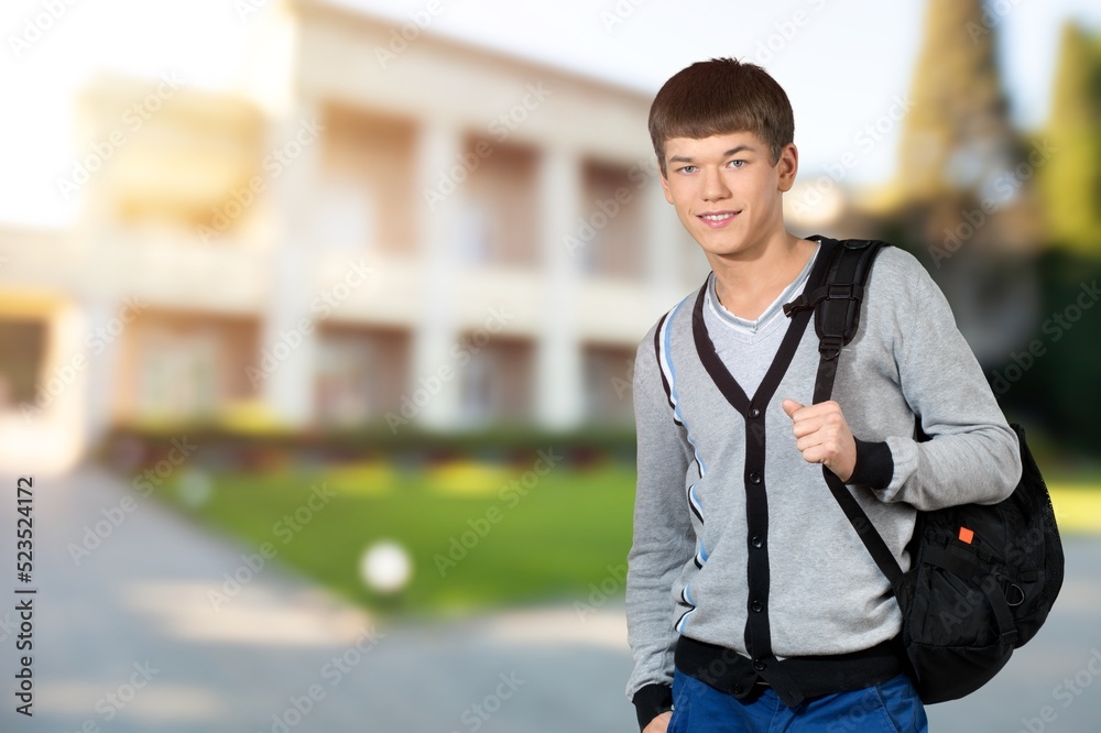 Happy school, college or university student with backpack. Cheerful handsome young man smiling