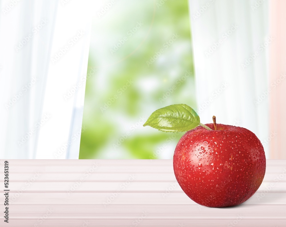 Red apple with green leaves on outdoor background