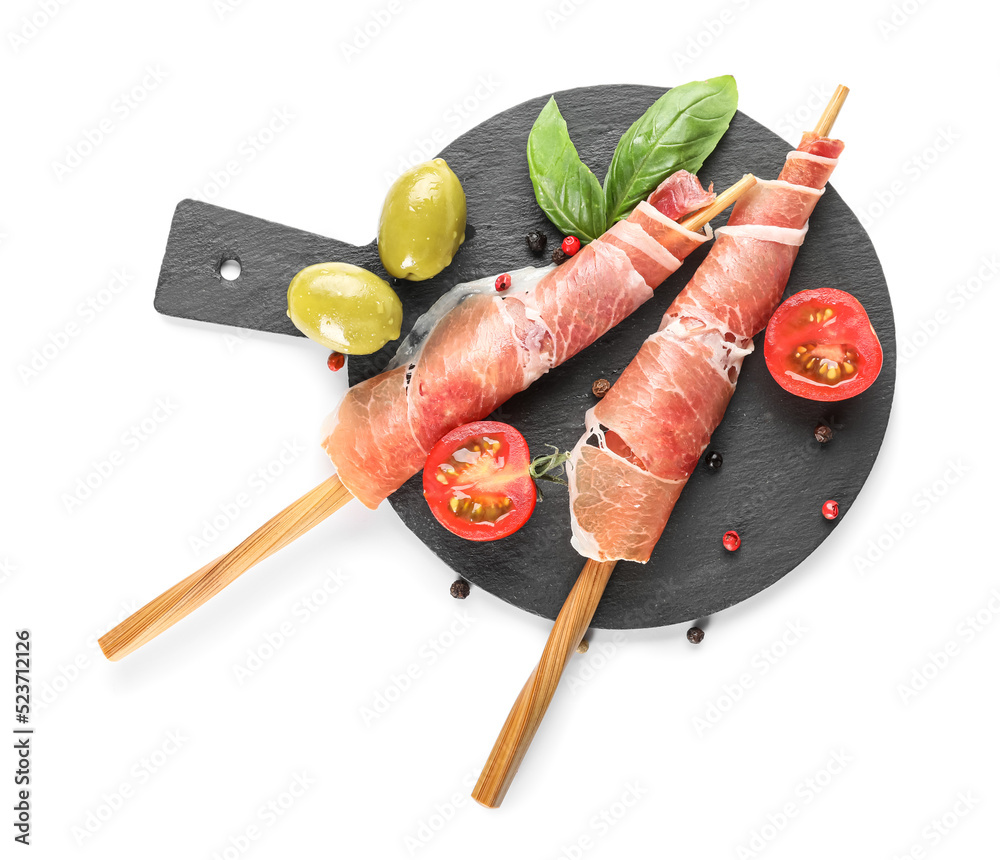 Slate board with delicious jamon on white background