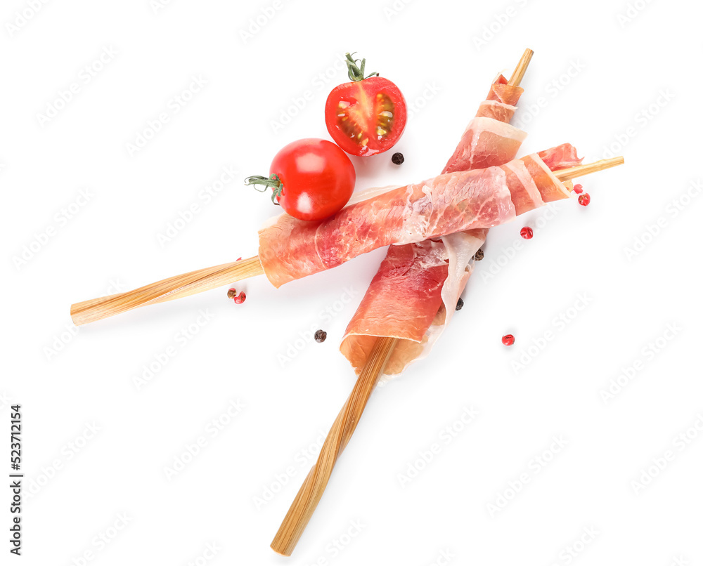 Chopsticks with  rolled delicious jamon on white background