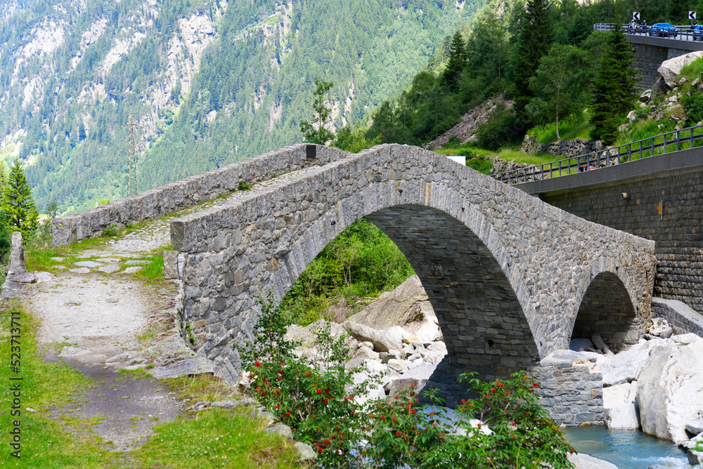 Beautiful scenic view of stone pedestrian bridge over Reuss River at Schöllenen Gorge on a sunny sum