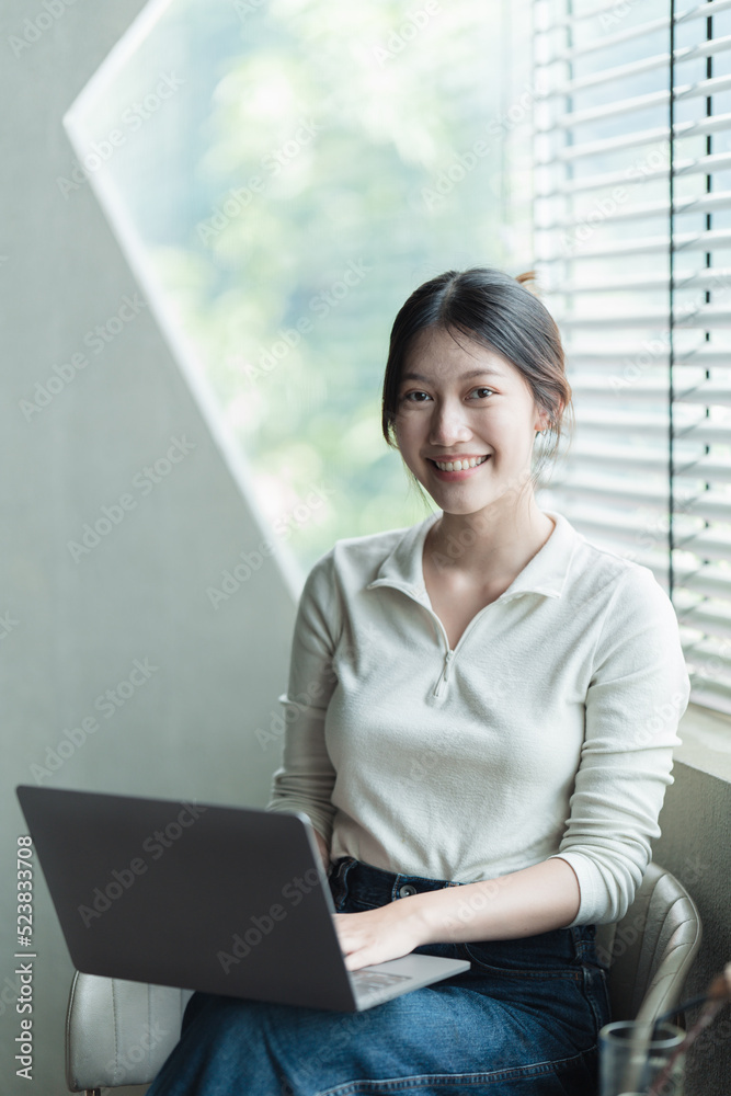 Asian woBeautiful young woman working on her laptop in her office.n working with laptop in her offic