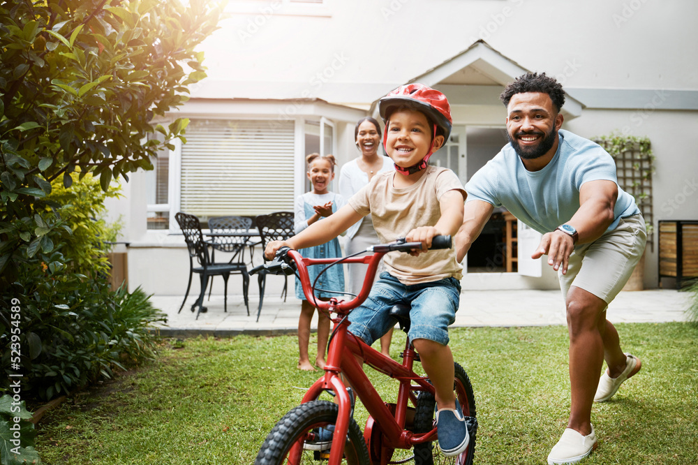 Learning, bicycle and proud dad teaching his young son to ride while wearing a helmet for safety in 