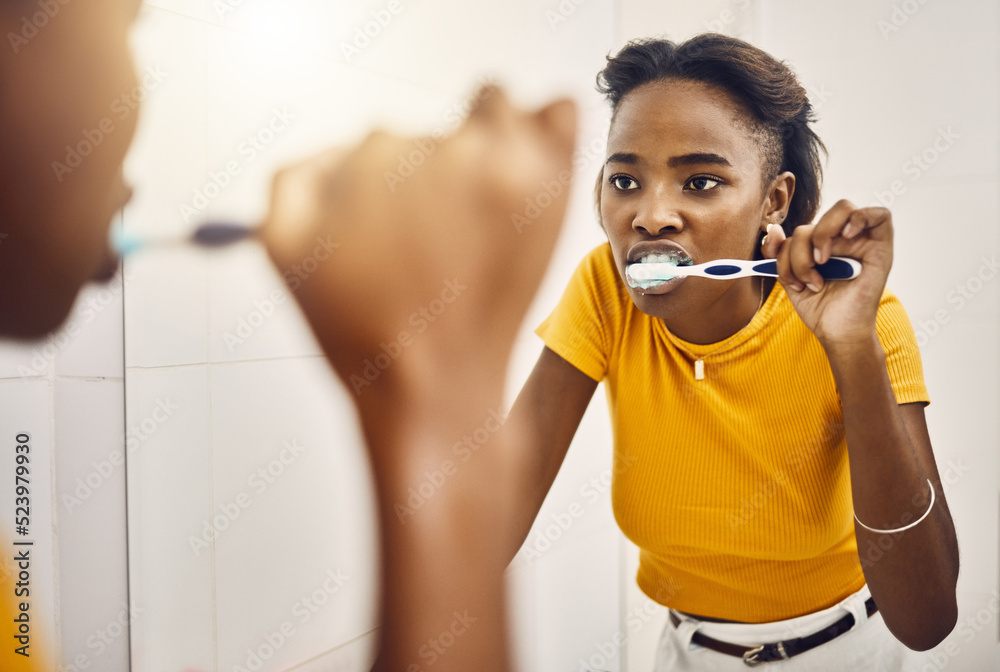 Brushing teeth, dental hygiene and oral care with a young woman looking at her reflection in the bat