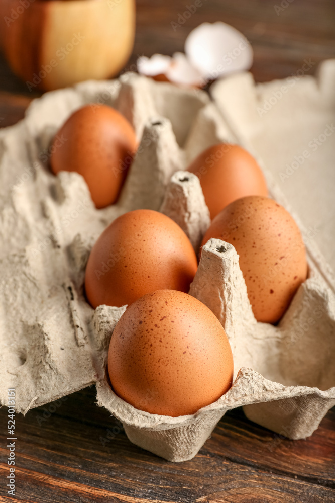 Cardboard holder with brown chicken eggs on table, closeup