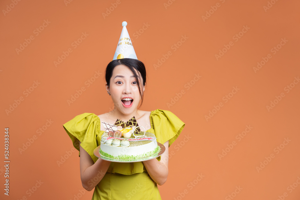 年轻的亚洲女人拿着生日蛋糕