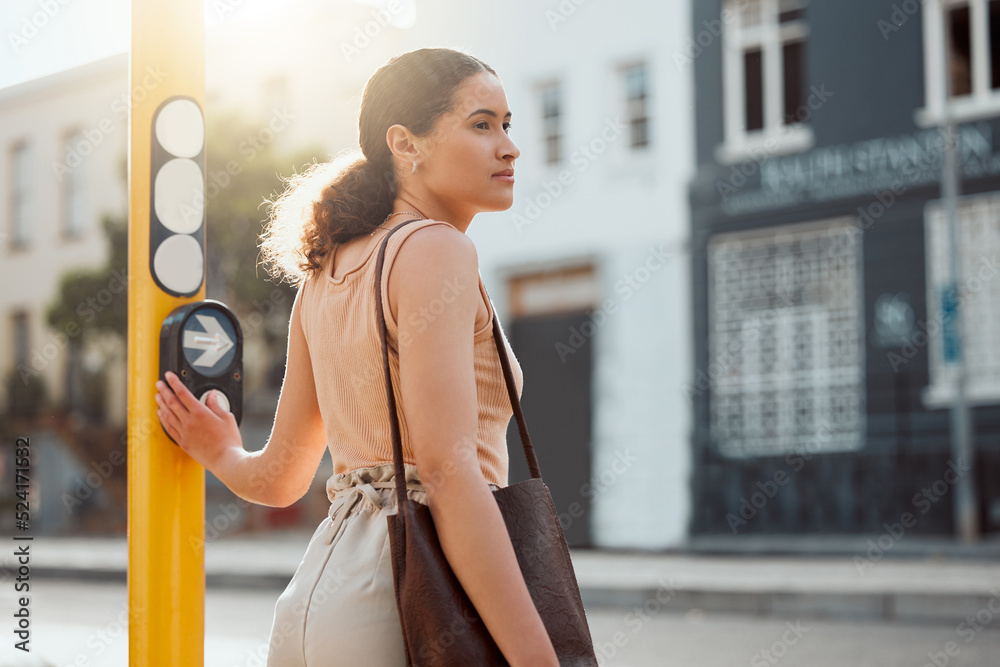 Attractive female pedestrian ready to cross the street, waiting for green light and pressing the but