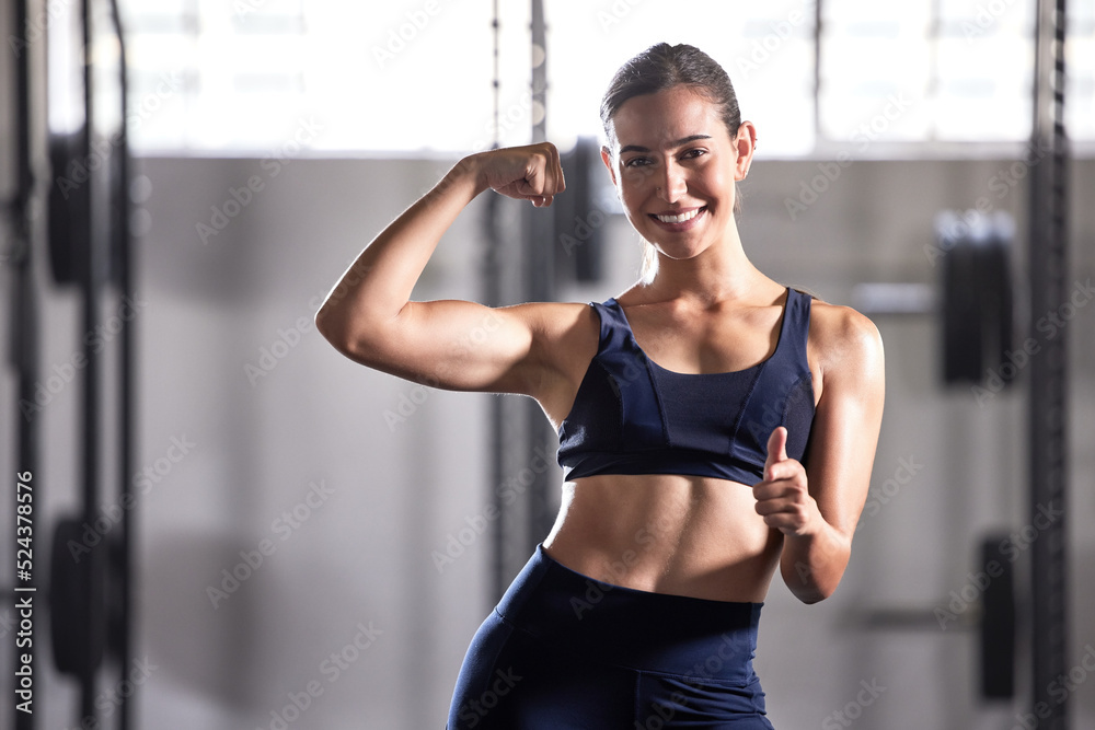 在健身房里，一个拥有健康肌肉的成功女性的强壮、健康和竖起大拇指的标志。肖像o