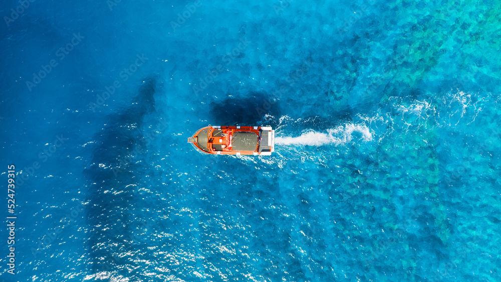 An aerial view of the yacht on the blue sea. Transparent clear water in the sea. Summer vacations an