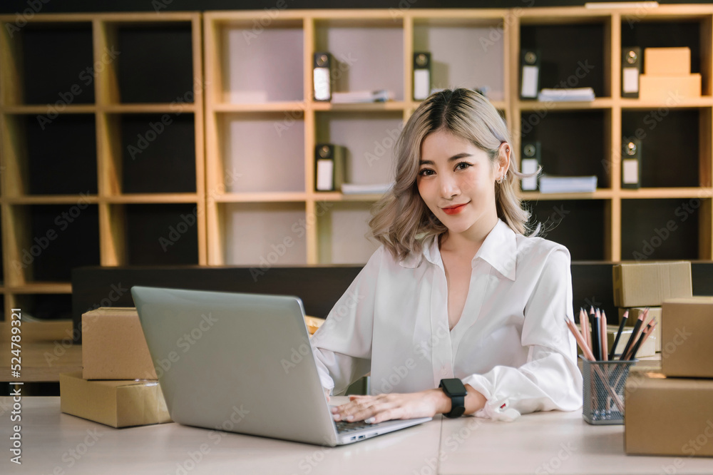 Woman hand using laptop, smartphone and tablet and writing notebook at office of her business online