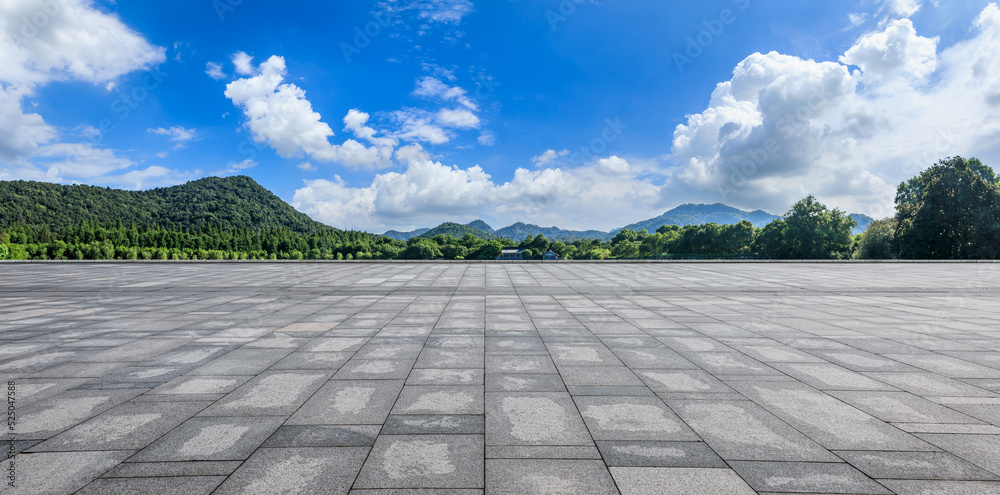 空旷的广场和绿色的森林，蓝天下的山景