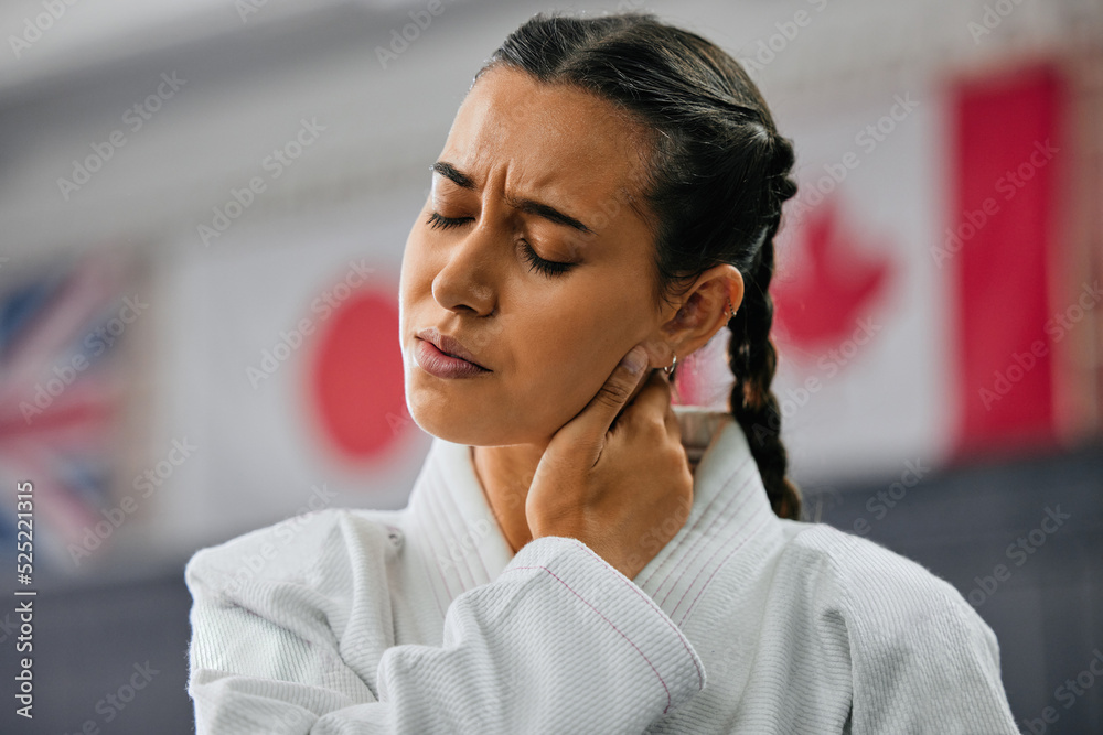 Woman karate student with bad neck pain at fitness training studio, person holding head from sport i