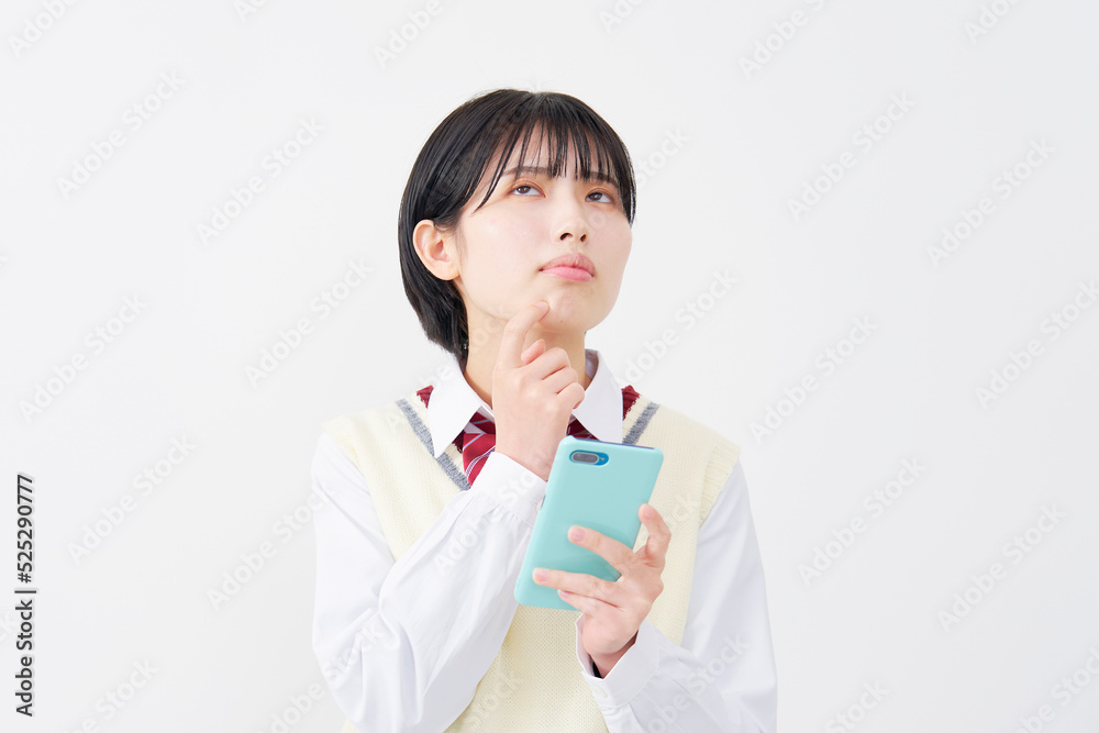 白背景でスマホを持って考える女子高生