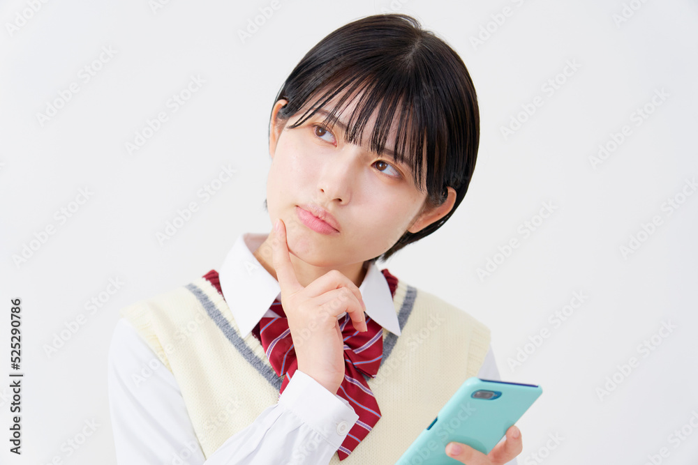 白背景でスマホを持って悩む女子高生