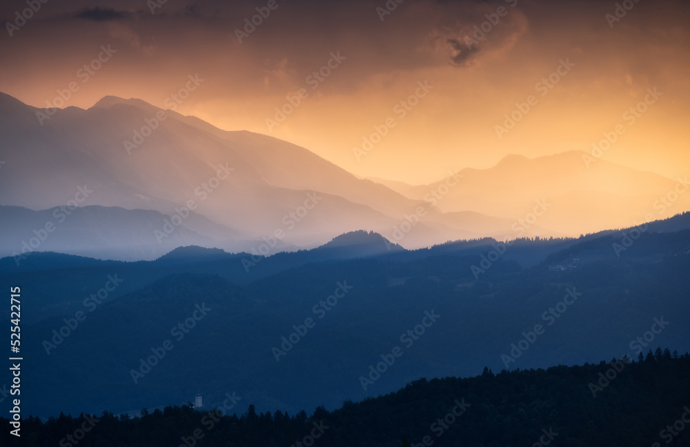 Amazing silhouettes of a mountains at colorful sunset in summer in Slovenia. Landscape with mountain