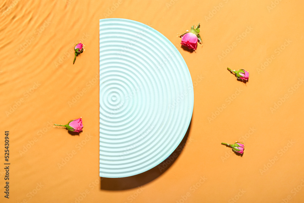 Decorative stand and rose flowers in water against color background