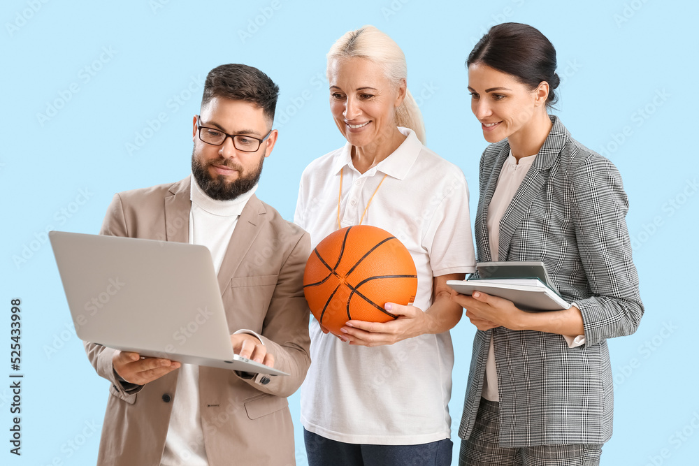 Teachers with laptop, ball and books on blue background