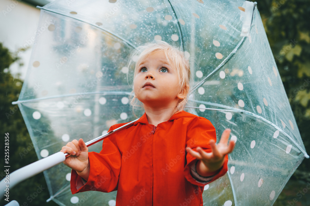 带着雨伞的孩子奇迹般的下雨天气穿着红色雨衣的户外蹒跚学步的女孩秋天