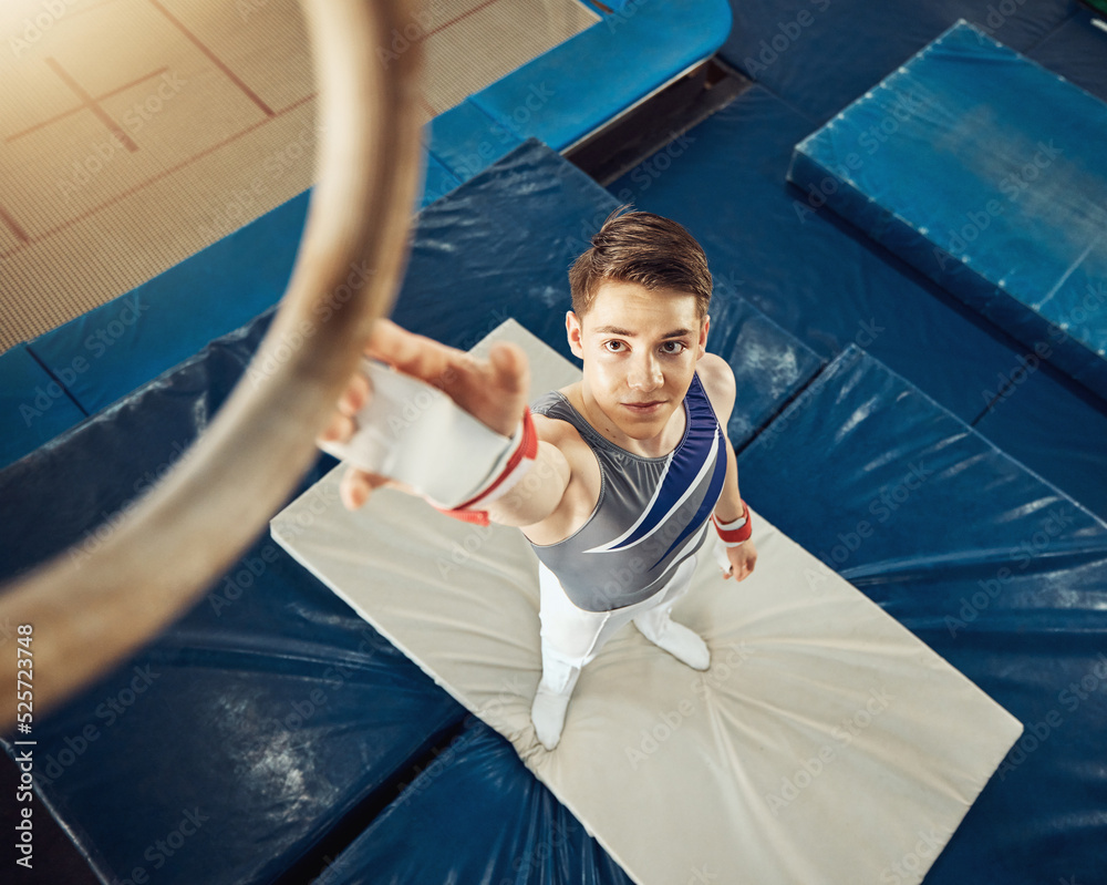 Sport, exercise and training ring for gymnastics exercise with a boy gymnast student in a gym. Top f