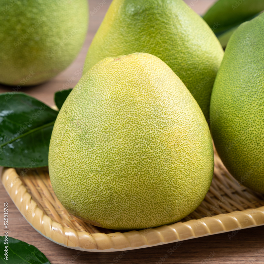 Fresh pomelo fruit on wooden table background.