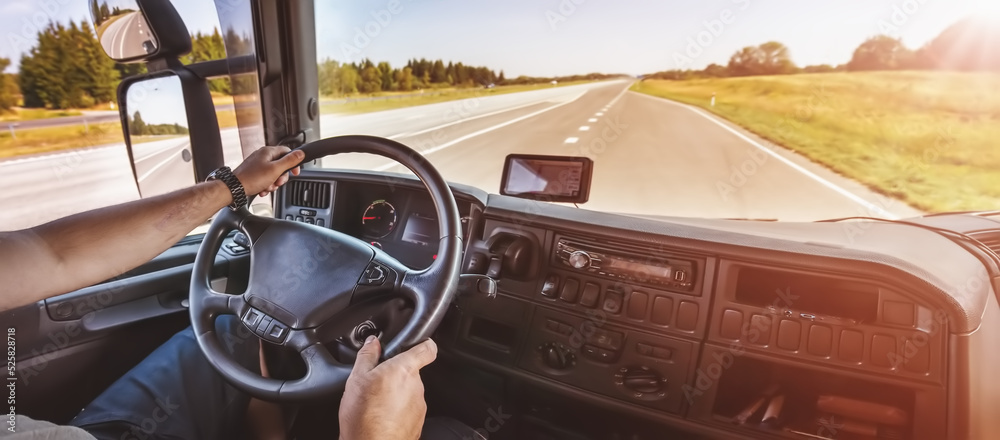 Driver of semi-truck sitting and drining his vehicle