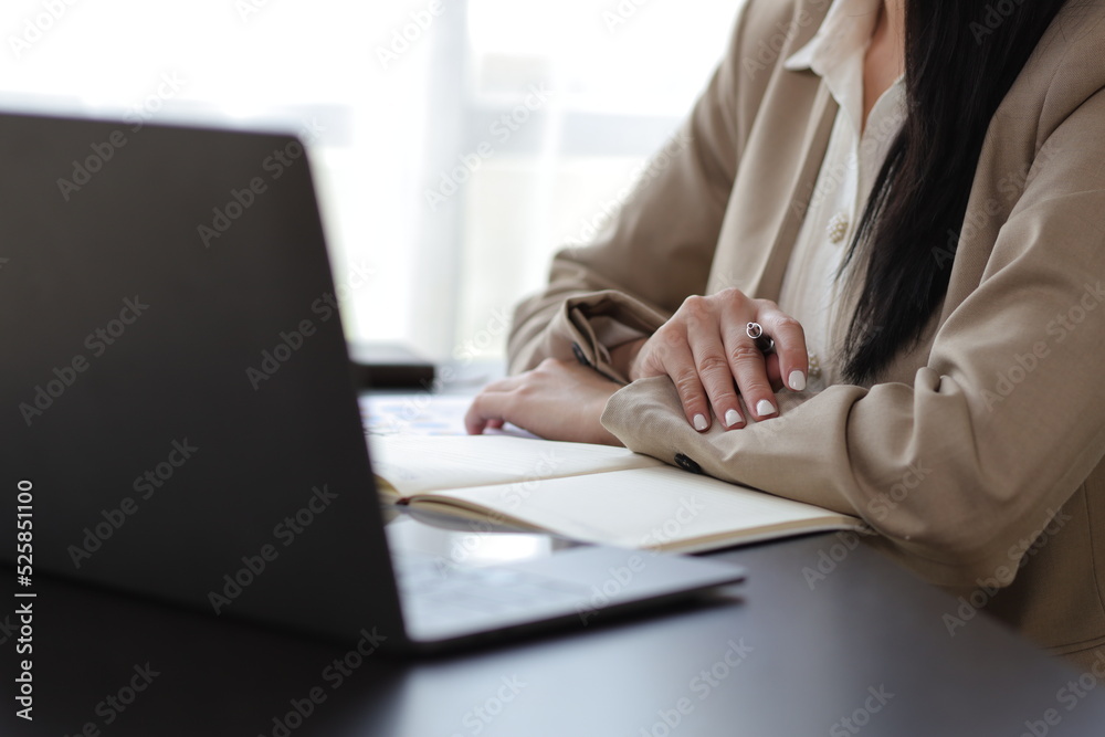 Attractive beautiful Asian business woman working on laptop on desk in office.