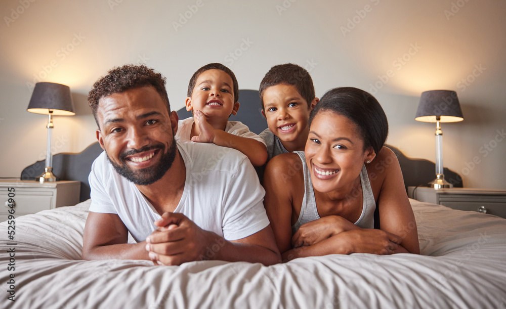 Portrait of happy black family on a bed with children, carefree, relaxing and playing in a bedroom t