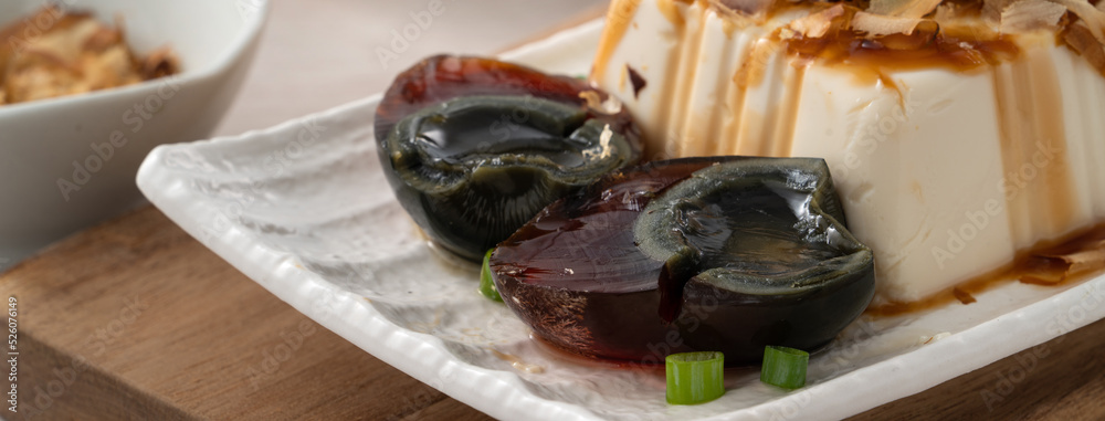 Delicious Chilled tofu and century egg with soy sauce and bonito flakes.