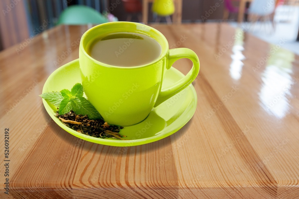 Ice tea with mint in cup with fresh mint leaves around. Homemade cold refreshing drink.