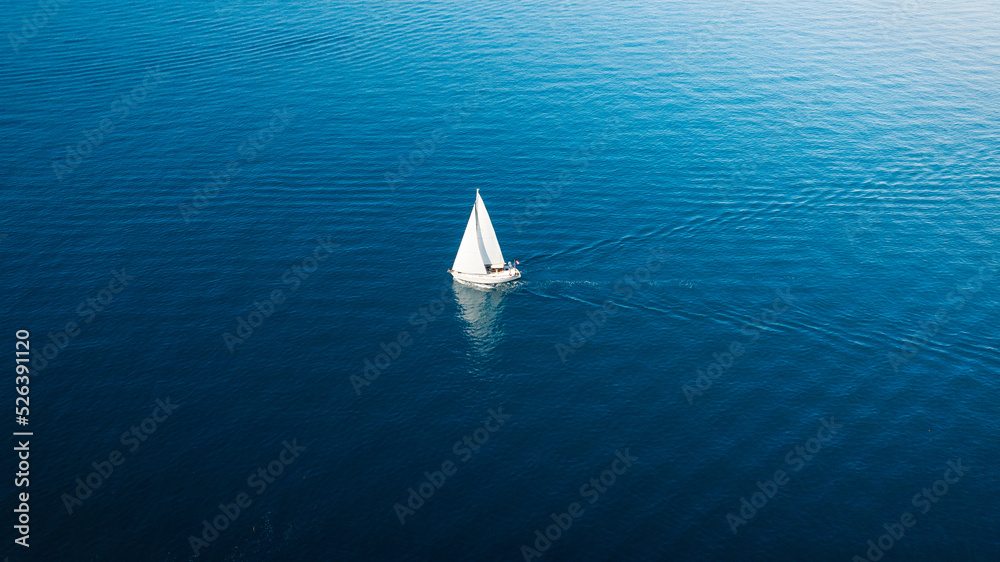 蓝色海面上的帆船鸟瞰图。海水清澈透明。避暑