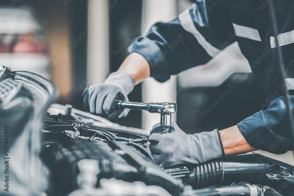 Mechanic works on the engine of the car in the garage. Repair se