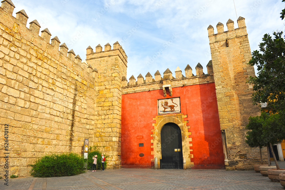 Turistas mirando los horarios en la Puerta del León en el Alcázar de Sevilla, Andalucía, España