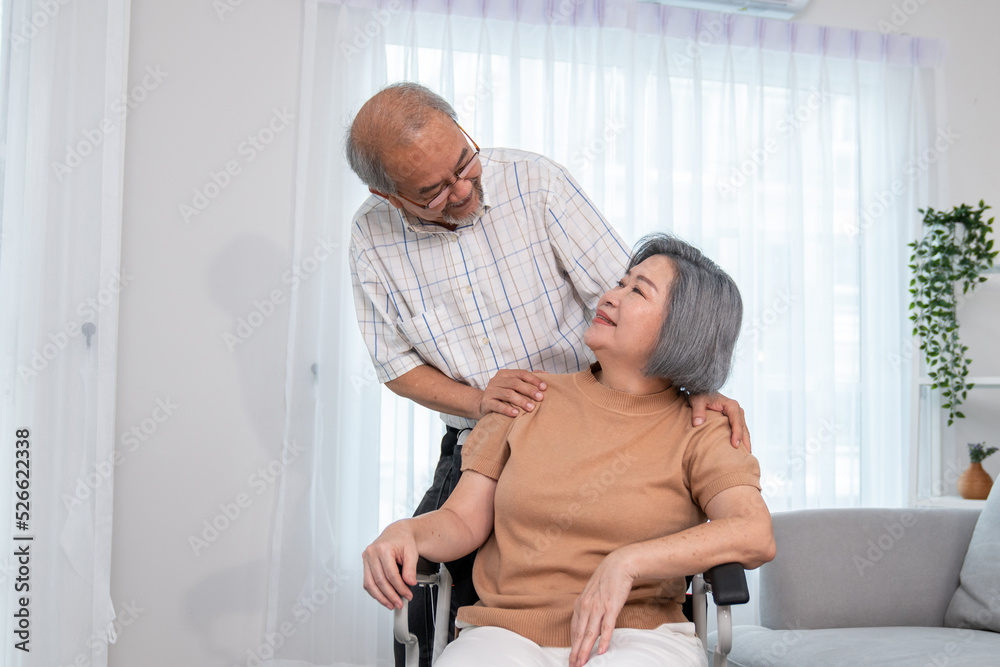 A contented senior couple and their in-home nurse. Elderly female in wheelchair with her young careg